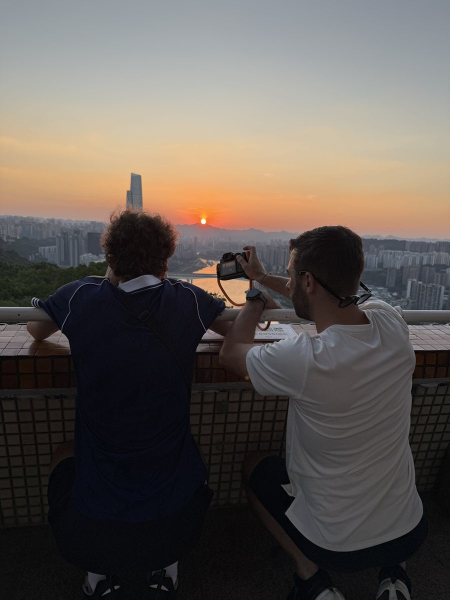 Guests photographing sunset above Chongqing's layered skyline