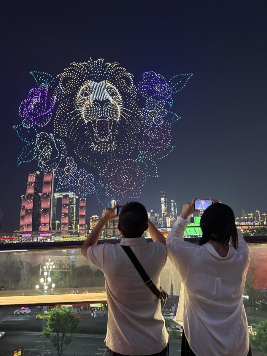 Guests watching Chongqing's scheduled drone show above the riverfront skyline