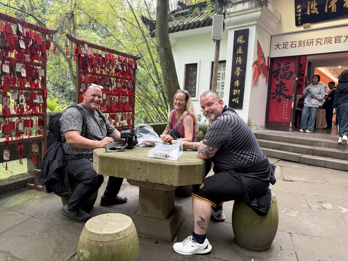 Three international guests taking a tea break along the forested Dazu route